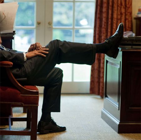 Obama with foot up on edge of desk
