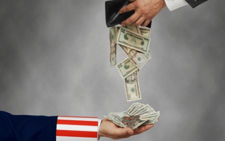 Businessman opening wallet with cash falling out into Uncle Sam's hand